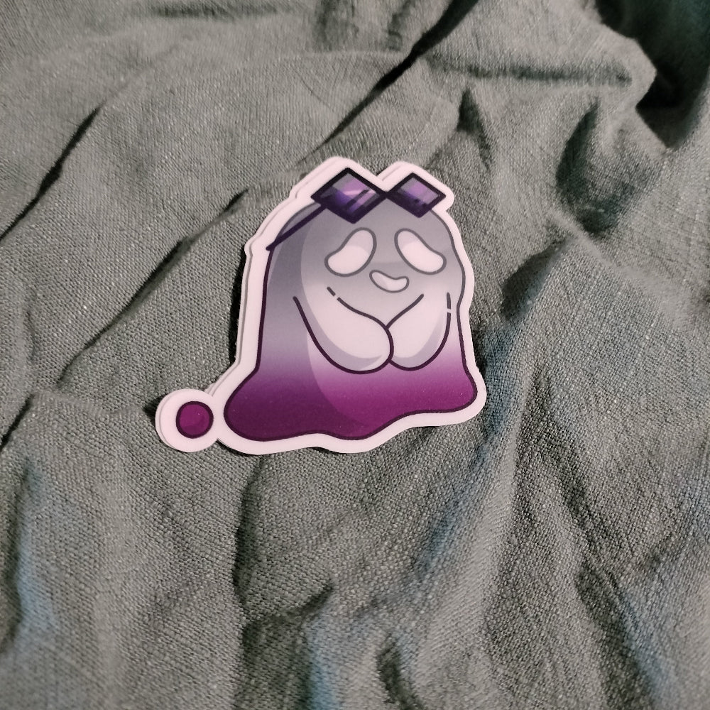 Sticker of a cartoon ghost on a textured gray fabric background