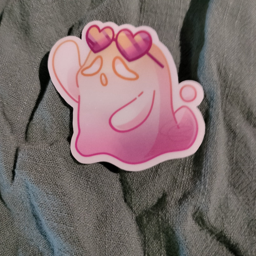 Pink cartoon character sticker with heart glasses on gray fabric background