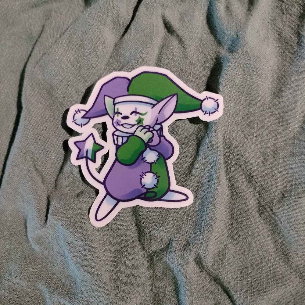 Cartoon character sticker with green and purple outfit on textured fabric background
