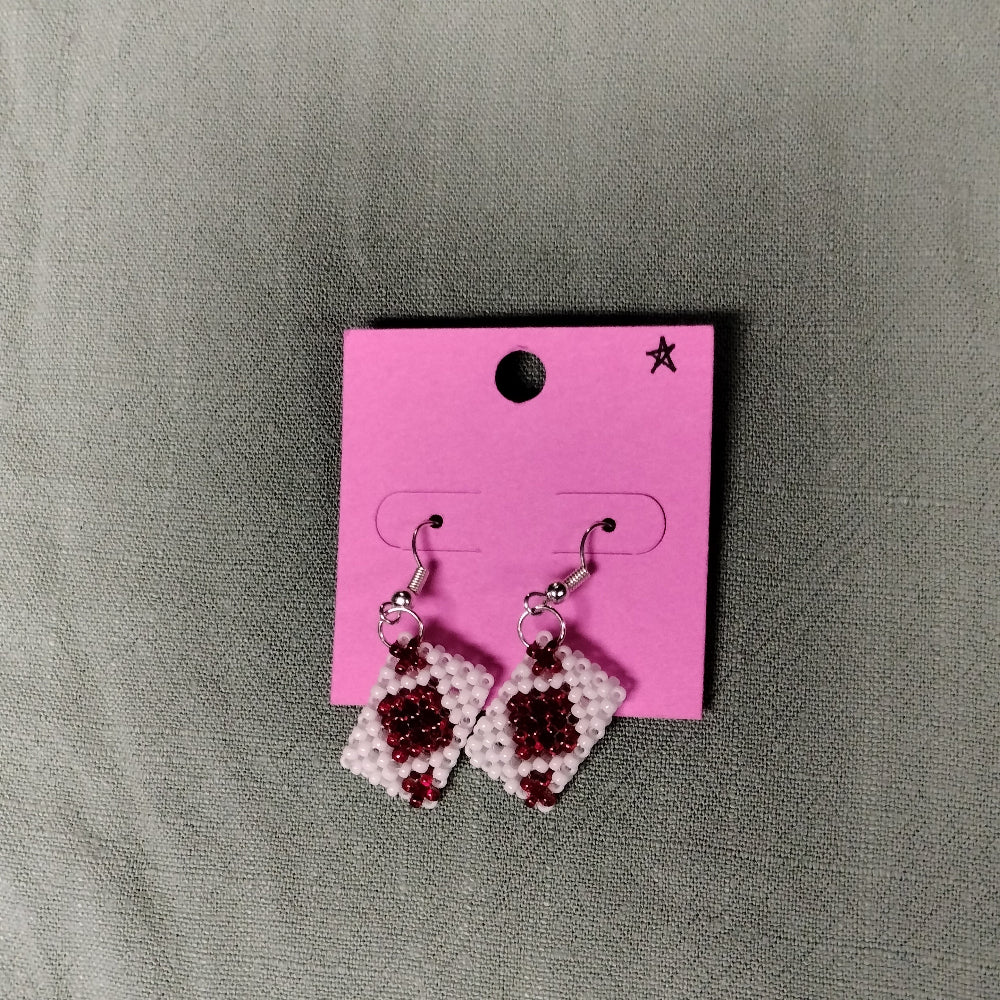 beaded playing card earrings on a pink card