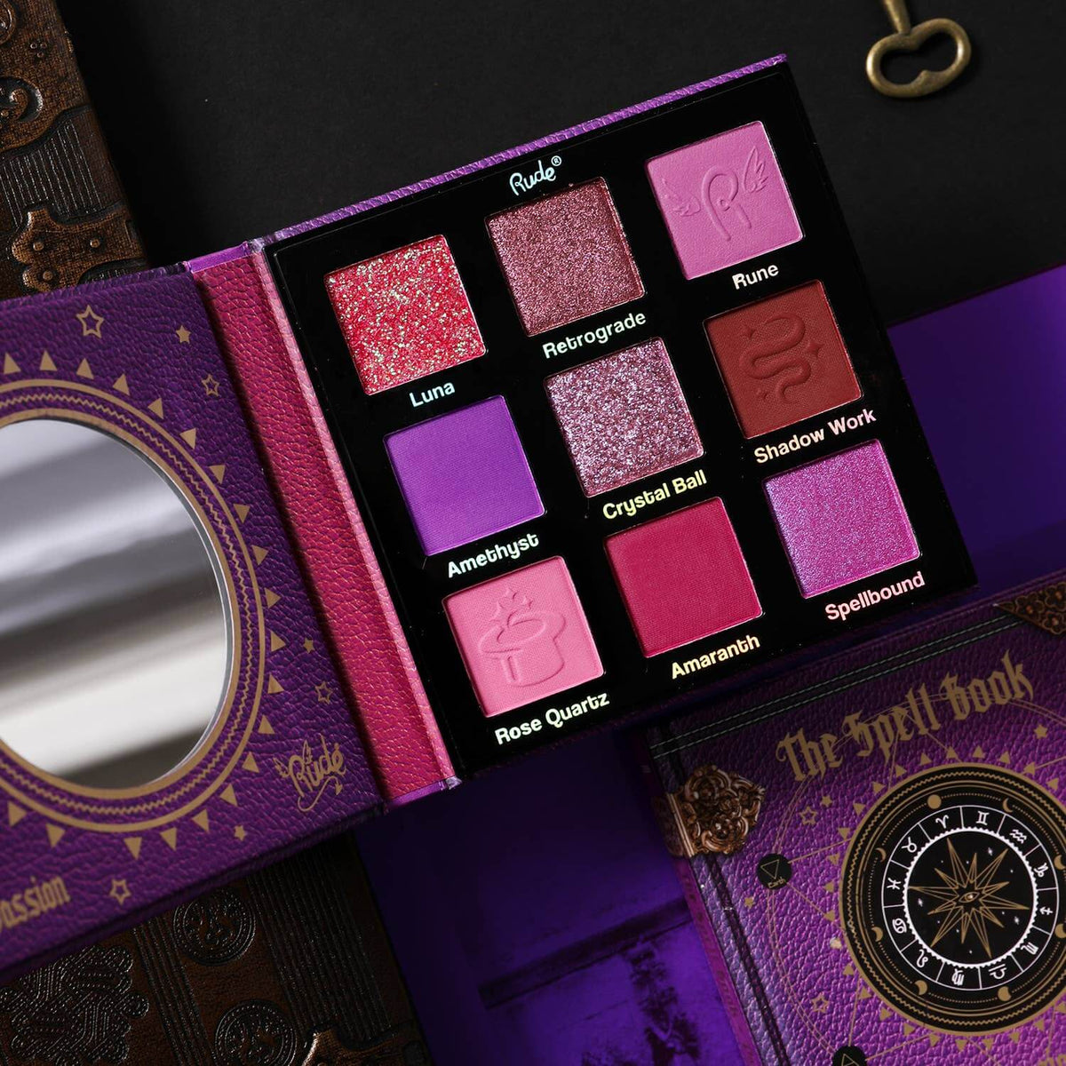 Eyeshadow palette featuring shades of pink, purple, and red on a purple and black background.