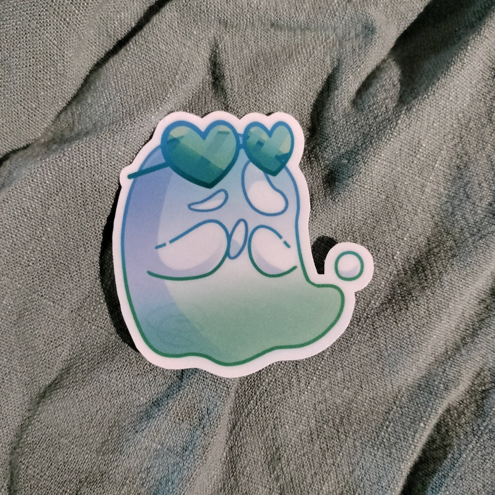 Sticker with a blue and green design on a textured gray surface