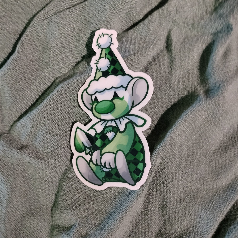 Cartoon character sticker with green outfit and hat on a textured fabric background