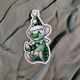 Cartoon character sticker with green outfit and hat on a textured fabric background