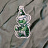 Cartoon character sticker with green outfit and hat on a textured fabric background