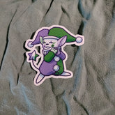Cartoon character sticker with green and purple outfit on textured fabric background