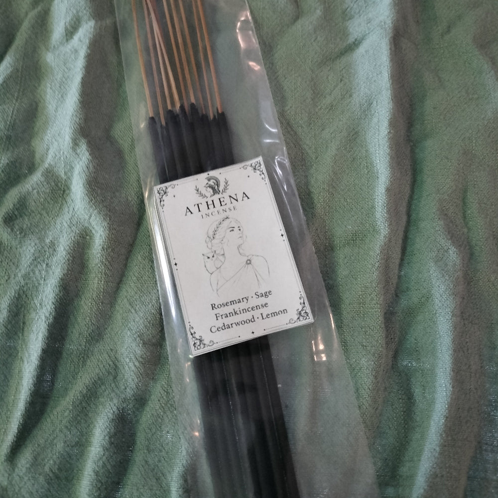 Pack of Athena incense sticks on a green fabric background