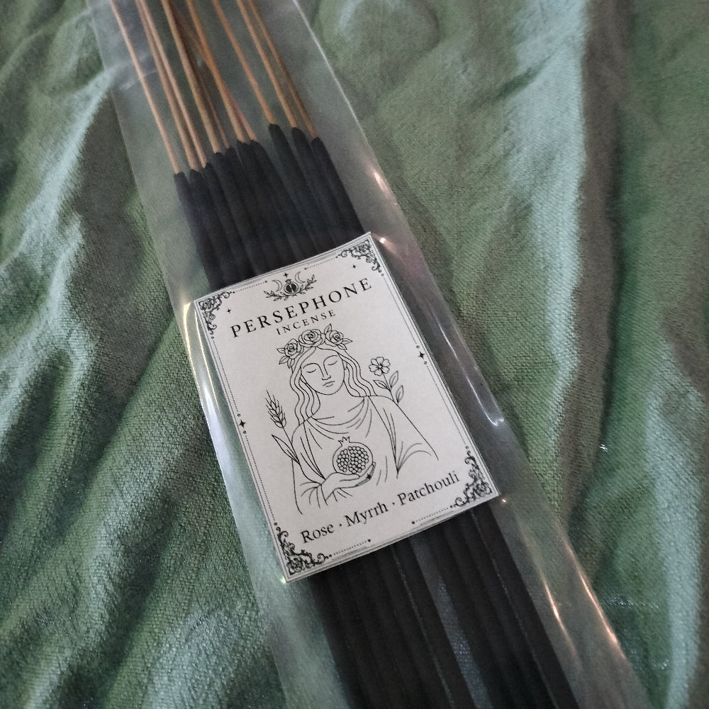 Pack of incense sticks with a Persephone label on a green fabric background