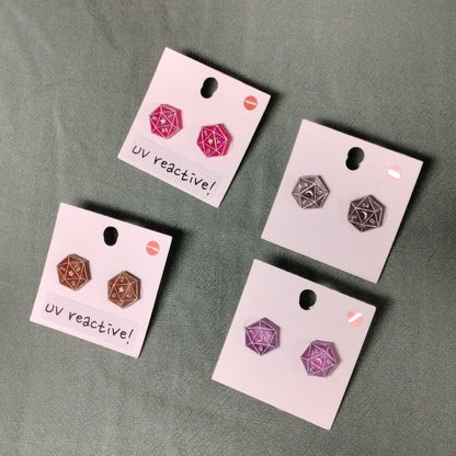 Set of UV reactive earrings on display cards against a gray background