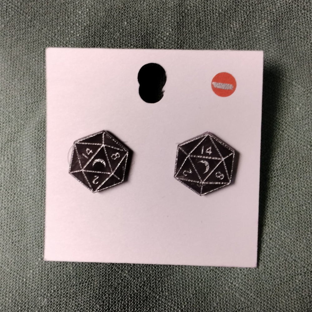 Black d20 dice earrings on a pink card with a gray background
