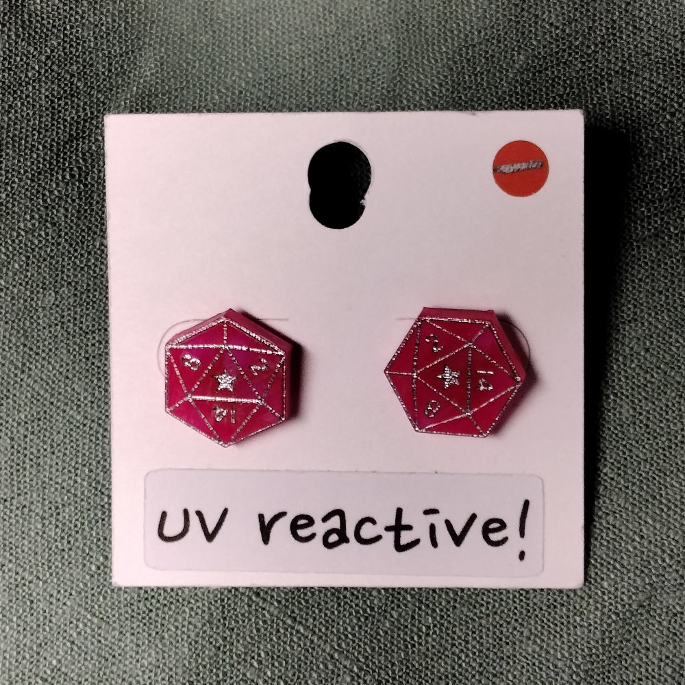 UV reactive earrings on a pink card with a gray background