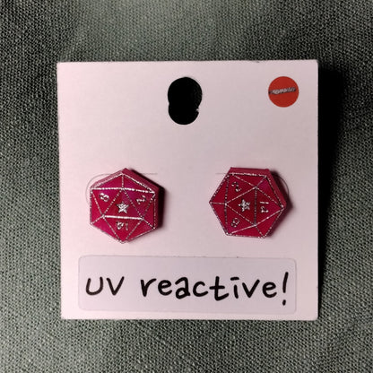 UV reactive earrings on a pink card with a gray background