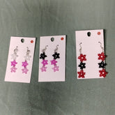 Three sets of beaded earrings on display cards against a green background