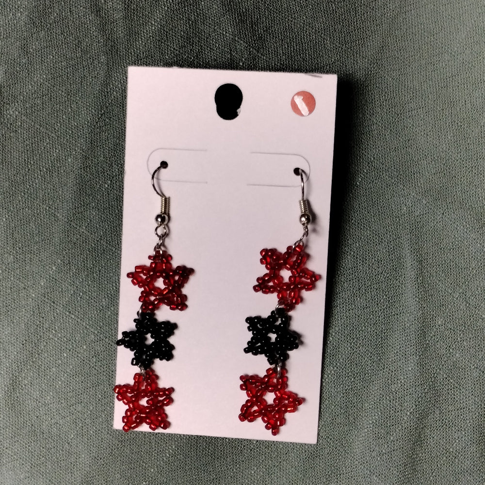 Star-shaped beaded earrings on a display card against a gray background