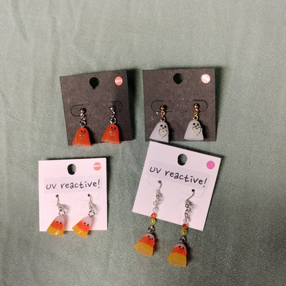 Set of Halloween-themed UV reactive earrings on display cards against a green background.