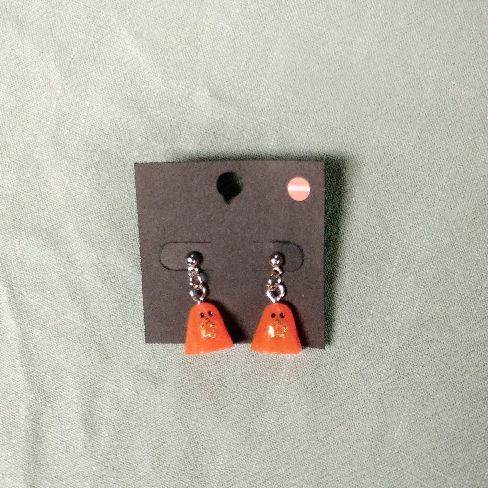 Pair of orange ghost-shaped earrings on a gray card against a light green background